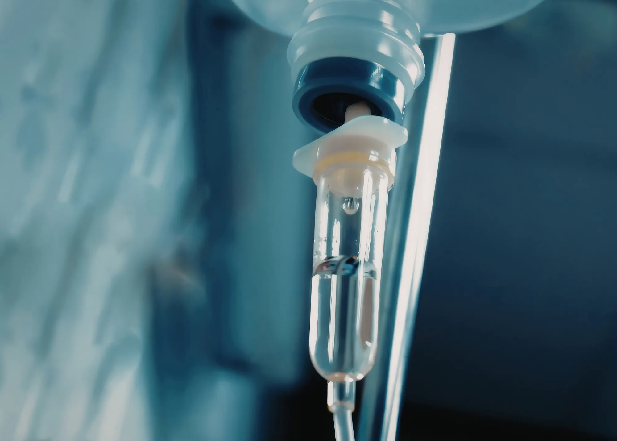 Close-up of an IV drip chamber with a falling drop