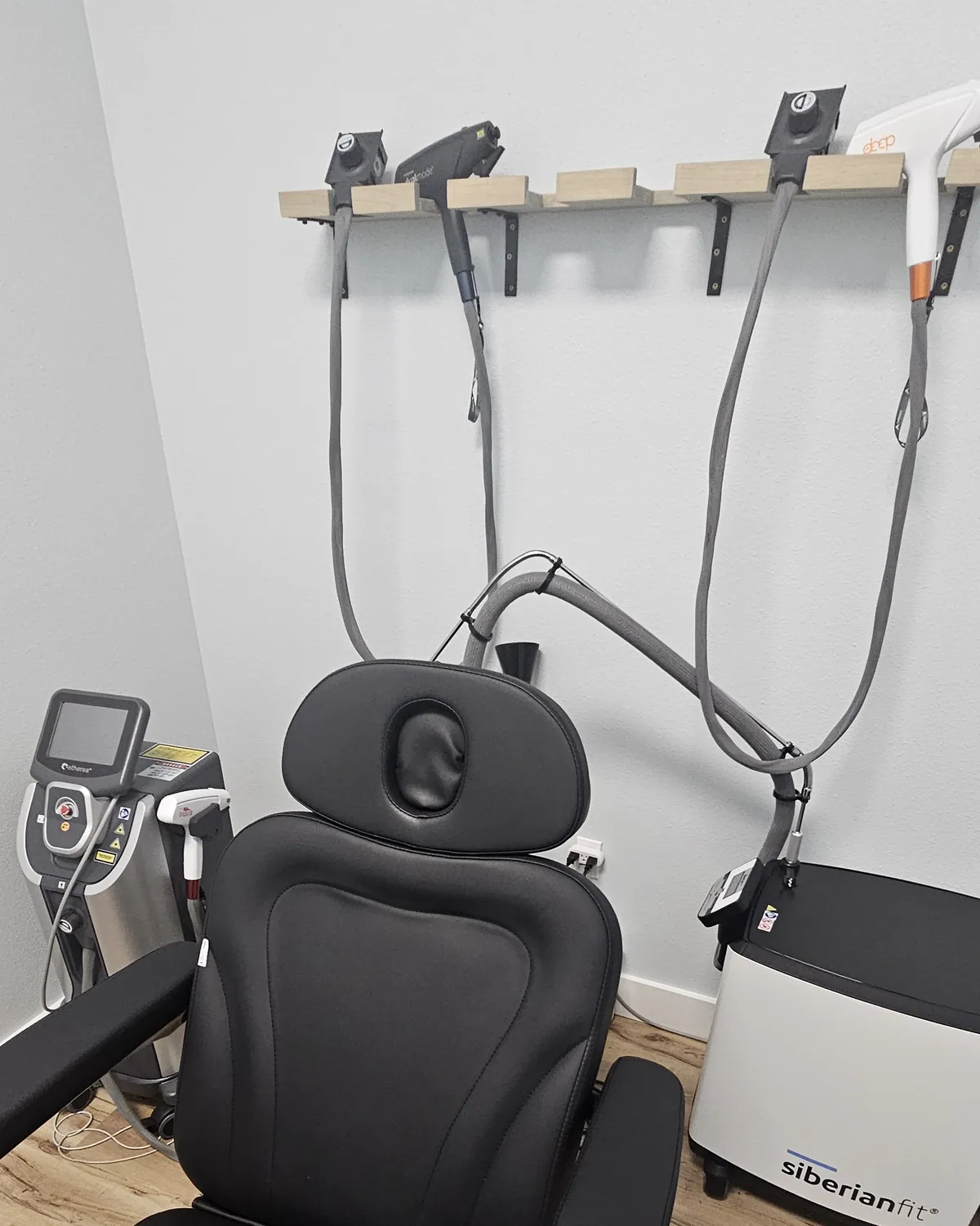 Laser room at Eternal MedSpa Sarasota: handpieces on a wall rack, the Etherea laser console and a treatment chair